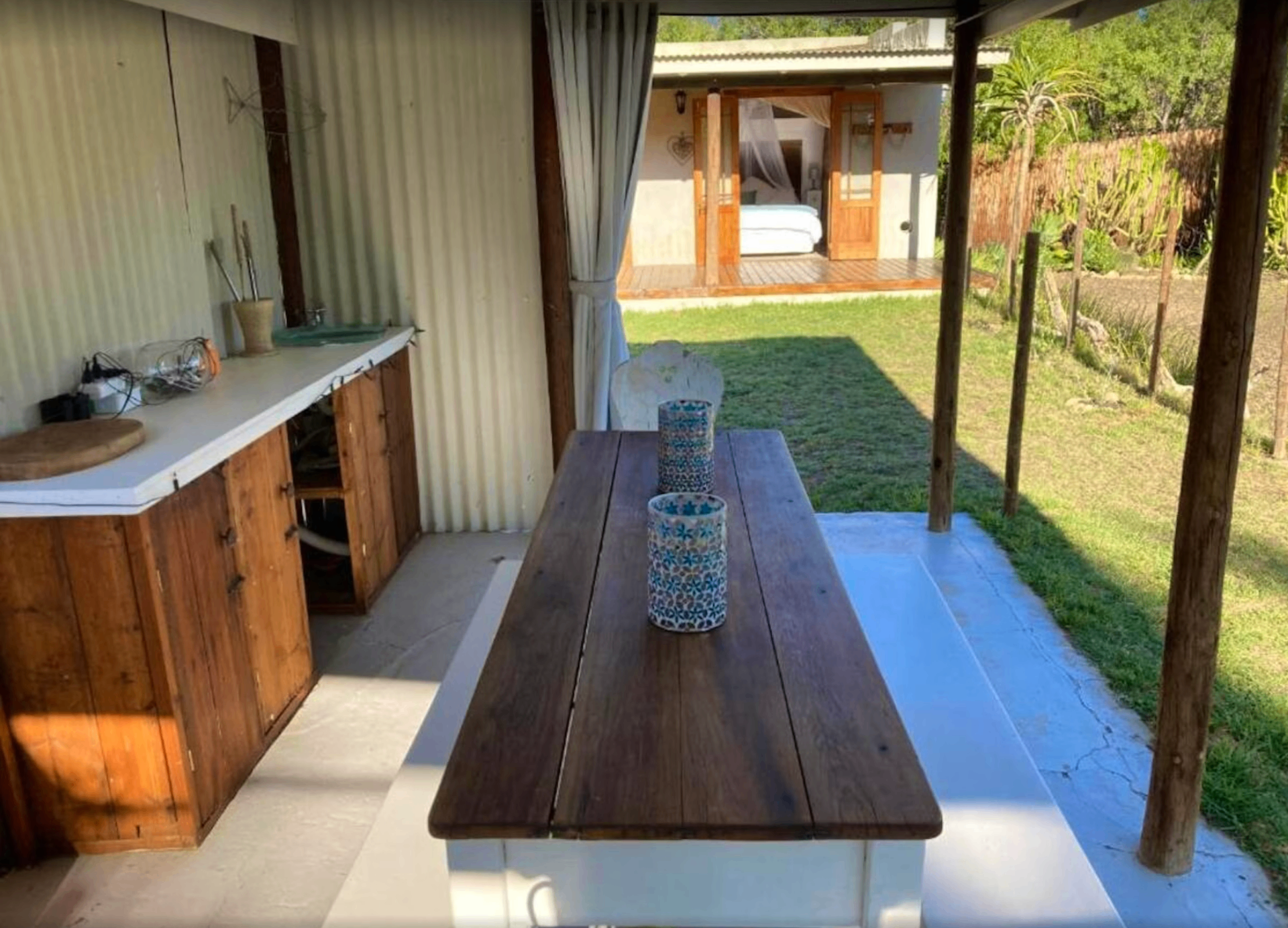 Covered braai patio at Karoo Feels with a Weber braai, wooden table and benches