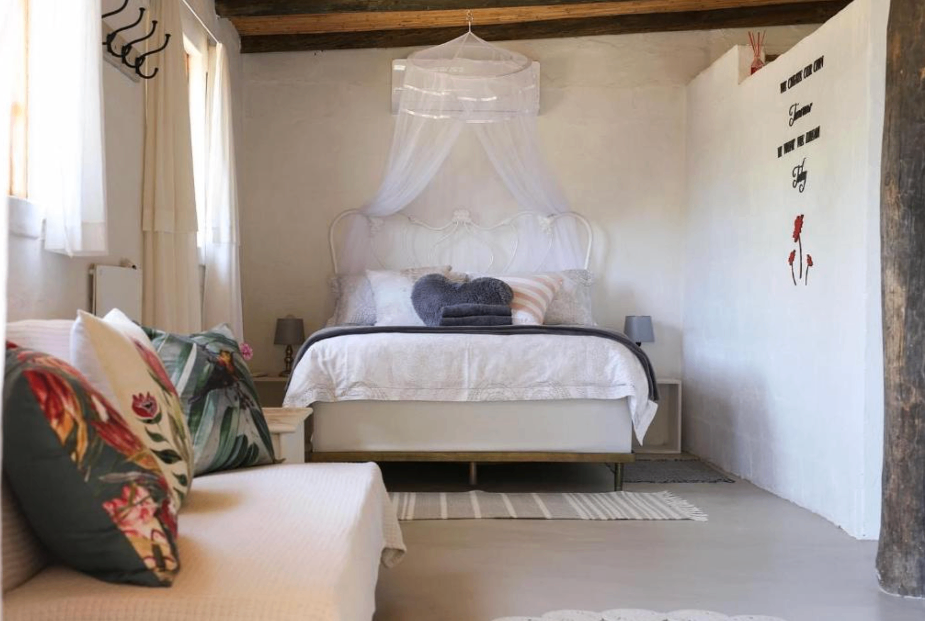 Canopy bedroom at Karoo Feels with white iron bed, mosquito net, and soft natural light.